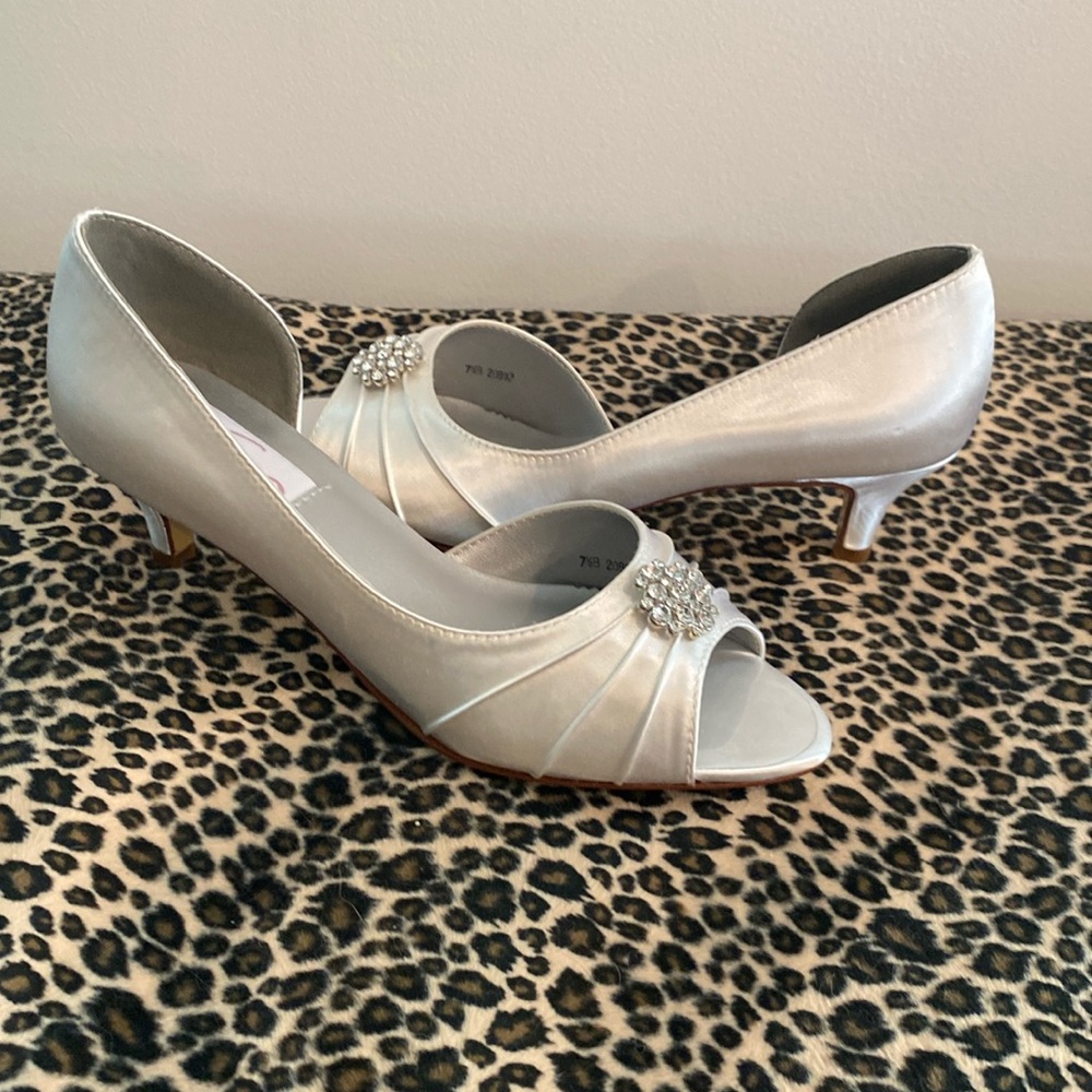 White satin peep toe pump with a rhinestone ornament The shoe is new